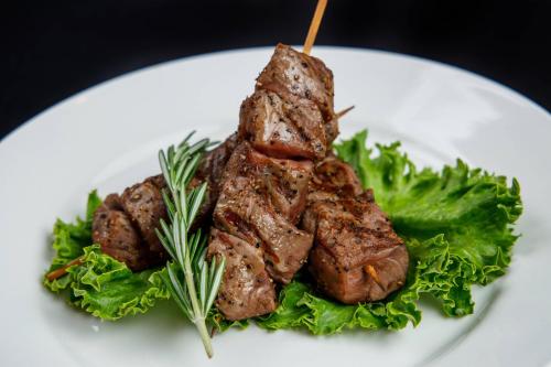 a piece of meat on a white plate with lettuce at Delta Hotels by Marriott Green Bay in Green Bay