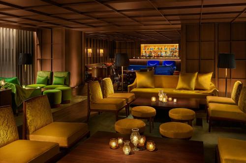 a restaurant with yellow and green furniture and tables at The Tokyo EDITION, Ginza in Tokyo