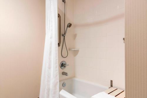 a bathroom with a shower with a white shower curtain at Delta Hotels by Marriott Kalamazoo Conference Center in Kalamazoo