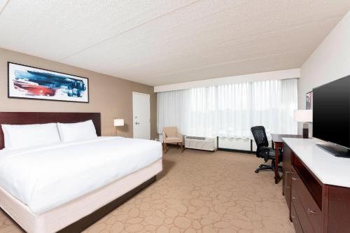 a hotel room with a bed and a television at Delta Hotels by Marriott Kalamazoo Conference Center in Kalamazoo