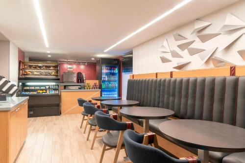 a restaurant with tables and chairs and a counter at Delta Hotels by Marriott Kalamazoo Conference Center in Kalamazoo