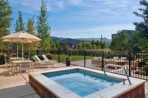 a swimming pool with a table and chairs and an umbrella at Element Basalt - Aspen in Basalt