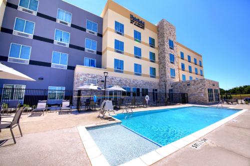 a hotel with a swimming pool in front of a building at Fairfield Inn & Suites by Marriott Dallas Cedar Hill in Cedar Hill