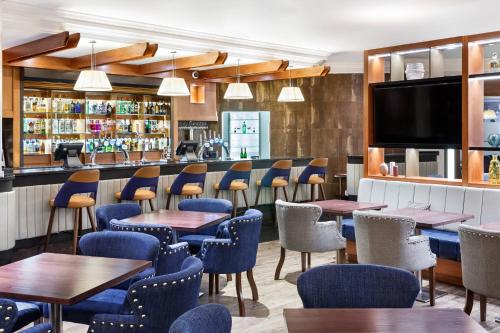 a restaurant with tables and chairs and a bar at Cheltenham Chase Hotel & Spa in Cheltenham