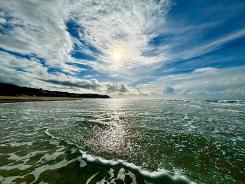 a view of a body of water with a cloudy sky at Tillicum Beach Motel - Formerly Deane's Oceanfront Lodge in Yachats
