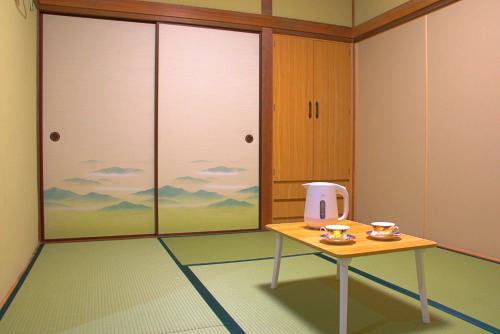 a room with a table with two cups on it at オレンジの風 in Imabari