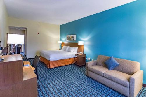 a hotel room with a bed and a couch at Fairfield Inn Charlotte Northlake in Charlotte