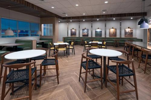 a restaurant with tables and chairs and a bar at Fairfield Inn & Suites Charlotte Monroe in Monroe