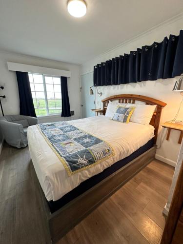 a bedroom with a large bed with a wooden headboard at Tillicum Beach Motel - Formerly Deane's Oceanfront Lodge in Yachats