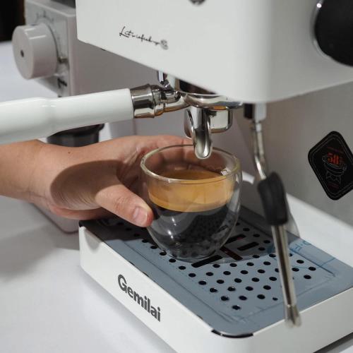 a person holding a cup of coffee in a espresso machine at Bankruchaem Homestay Kohpu in Ban Klang