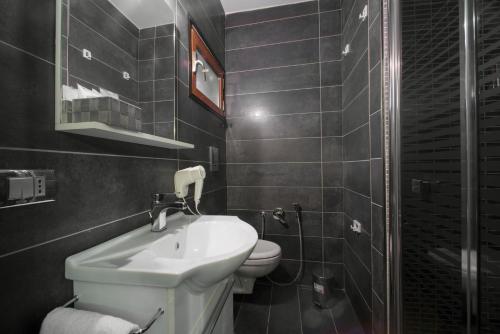 a bathroom with a sink and a toilet at Il Taschino Suite in Naples