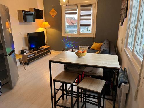 a living room with a table and a couch at Ouitreham Port & Mer in Ouistreham