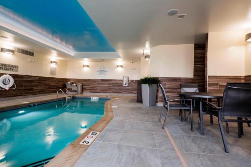 a pool in a hotel room with a table and chairs at Fairfield Inn & Suites by Marriott Chillicothe in Chillicothe