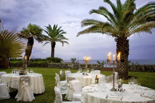 a wedding reception with white tables and palm trees at Delta Hotels by Marriott Giardini Naxos in Giardini Naxos