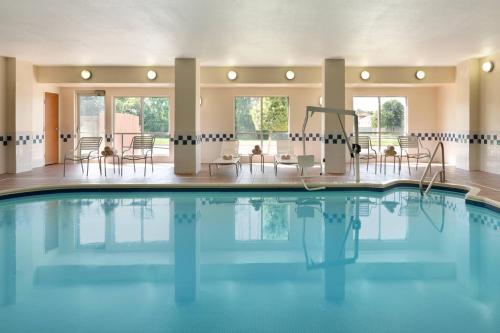 a swimming pool with tables and chairs in a building at Fairfield Inn & Suites Dallas Mesquite in Mesquite