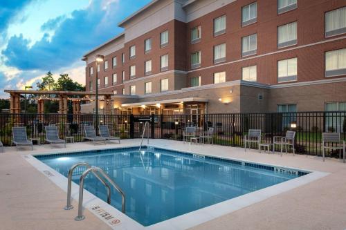 a hotel with a swimming pool in front of a building at Fairfield Inn & Suites Charlotte Pineville in Charlotte