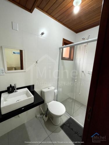 a bathroom with a toilet and a sink and a shower at Departamento 3- Pinheira in Praia de Cima (Pinheira)