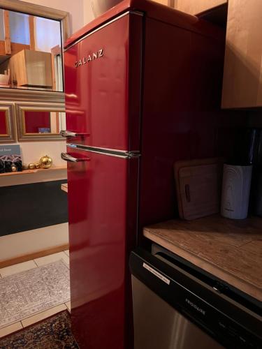 a red refrigerator in a kitchen with a counter at PRIVATE HOUSE and private HOT TUB Seas The Day Pets BBQ Beaches Artists Studio Lower Gibsons The Bay in Gibsons
