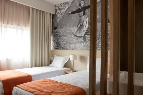 a hotel room with two beds and a painting on the wall at Porto Coliseum Hotel in Porto