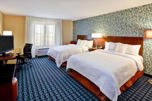 a hotel room with two beds and a television at Fairfield Inn & Suites by Marriott Jeffersonville I-71 in Jeffersonville