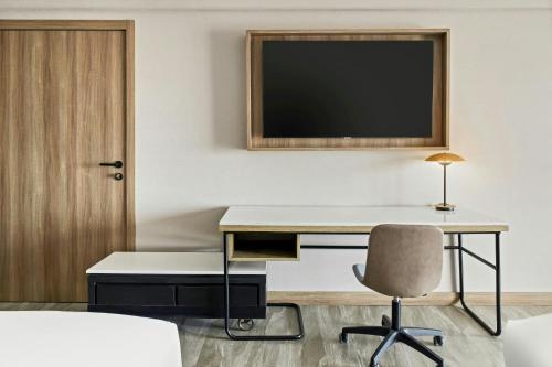 a room with a desk and a television on a wall at Courtyard by Marriott San Jose Escazu in San José