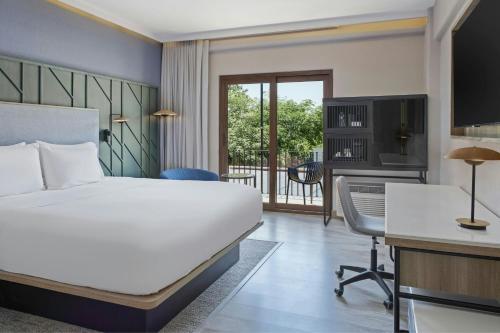 a hotel room with a bed and a desk and a computer at Courtyard by Marriott San Jose Escazu in San José