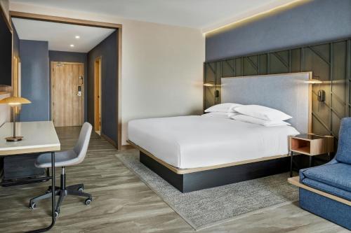 a bedroom with a bed and a desk and a chair at Courtyard by Marriott San Jose Escazu in San José