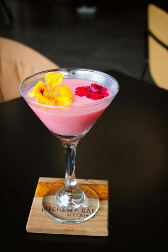 a drink in a martini glass with flowers in it at Courtyard by Marriott San Jose Escazu in San José