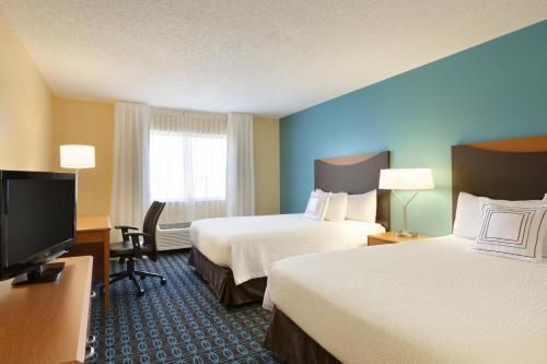 a hotel room with two beds and a flat screen tv at Fairfield Inn Colorado Springs Air Force Academy in Colorado Springs