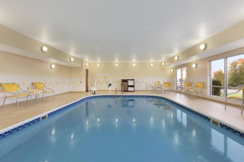 a pool in a hotel with yellow chairs and tables at Fairfield Inn Colorado Springs Air Force Academy in Colorado Springs