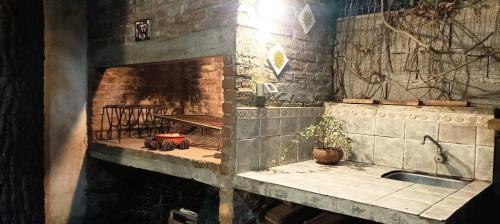 a kitchen with a sink and a brick fireplace at Hostal Pino Alto in El Pinar