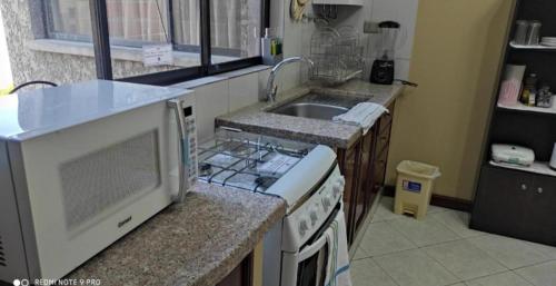 a kitchen with a stove and a sink at Departamentos Vacacionales Tarija in Tarija