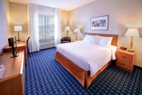 a hotel room with a large bed and a television at Fairfield Inn & Suites by Marriott Wausau in Weston