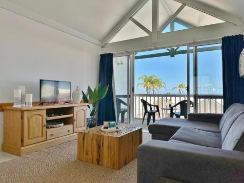 a living room with a couch and a tv at Waterfront Unit 4 - Kalbarri WA in Kalbarri