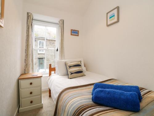 a small bedroom with a bed and a window at Calac Cottage in Mousehole