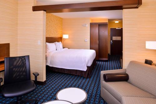 a hotel room with a bed and a couch at Fairfield Inn & Suites by Marriott Plymouth White Mountains in Plymouth
