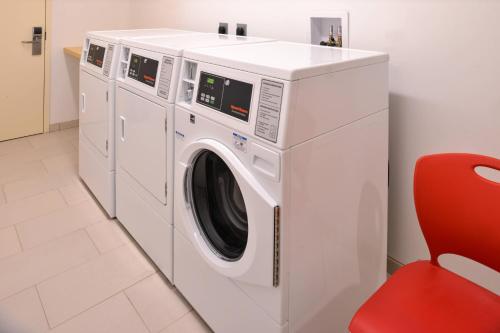 a white washing machine in a room with a red chair at Fairfield Inn & Suites by Marriott Plymouth White Mountains in Plymouth