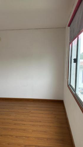 an empty room with a window and a wooden floor at Casa con piscina Atlántida in Atlántida