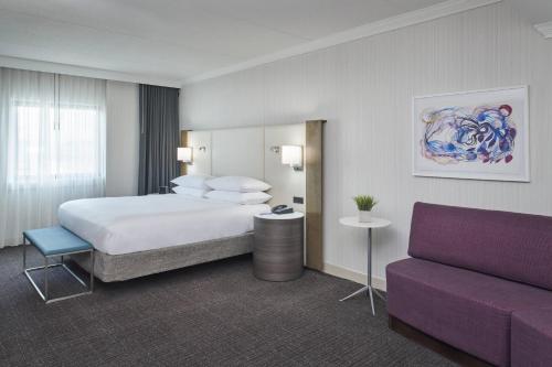 a hotel room with a bed and a couch at Delta Hotels by Marriott Detroit Novi in Farmington Hills