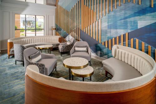 a waiting room with chairs and tables and stairs at Delta Hotels by Marriott Huntington Downtown in Huntington