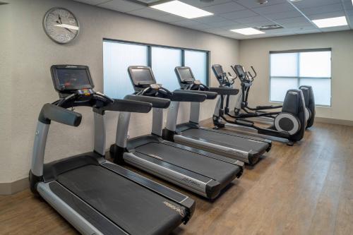 a row of treadmills in a gym with a clock at Delta Hotels by Marriott Huntington Downtown in Huntington