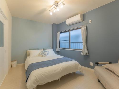 una piccola camera da letto con un letto e una finestra di 心斎橋梅田京都usjなど人気観光エリアへアクセス抜群4ベットルーム3階建て貸切 ad Osaka