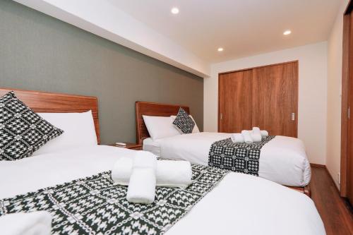 a hotel room with two beds with white sheets at Nihonbashi Royal in Osaka
