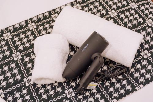 a hair dryer and towels on a table at Nihonbashi Royal in Osaka