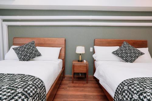 two beds sitting next to each other in a bedroom at Nihonbashi Royal in Osaka