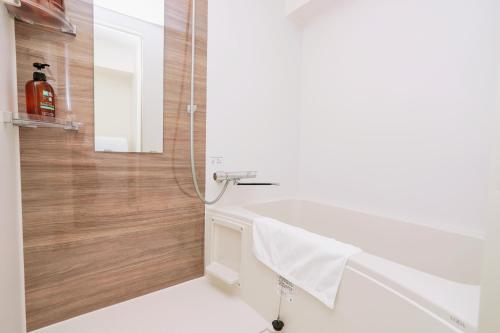 a bathroom with a shower and a white sink at Nihonbashi Royal in Osaka