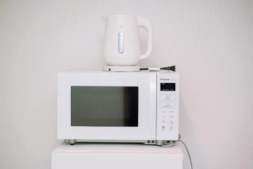 a white microwave with a coffee pot on top of it at Nihonbashi Royal in Osaka