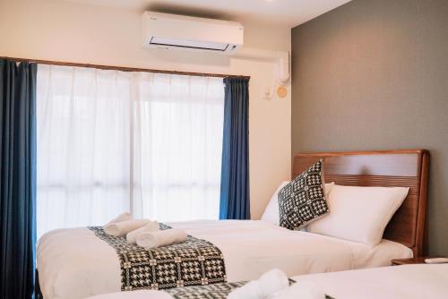 a bedroom with two beds and a window at Nihonbashi Royal in Osaka