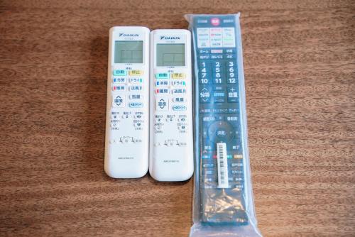 three remote controls sitting next to each other on a table at Nihonbashi Royal in Osaka