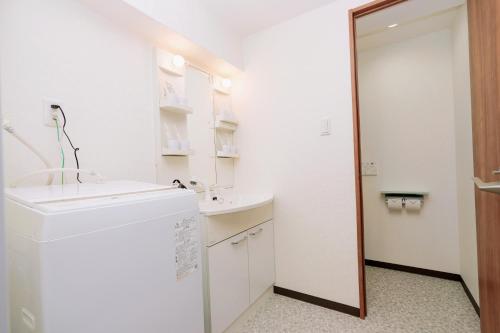 a white bathroom with a sink and a mirror at Nihonbashi Royal in Osaka